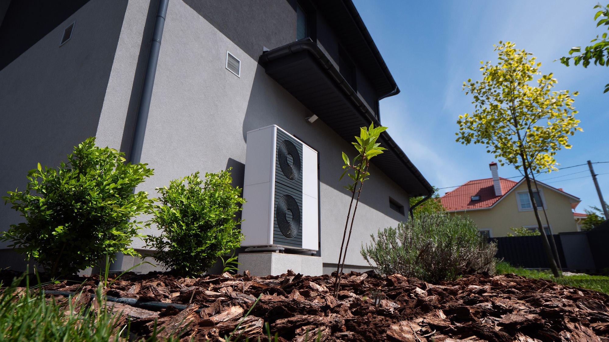 Ein Wohnhaus mit einem weißen Klimagerät, das prominent vor dem Gebäude platziert ist.
